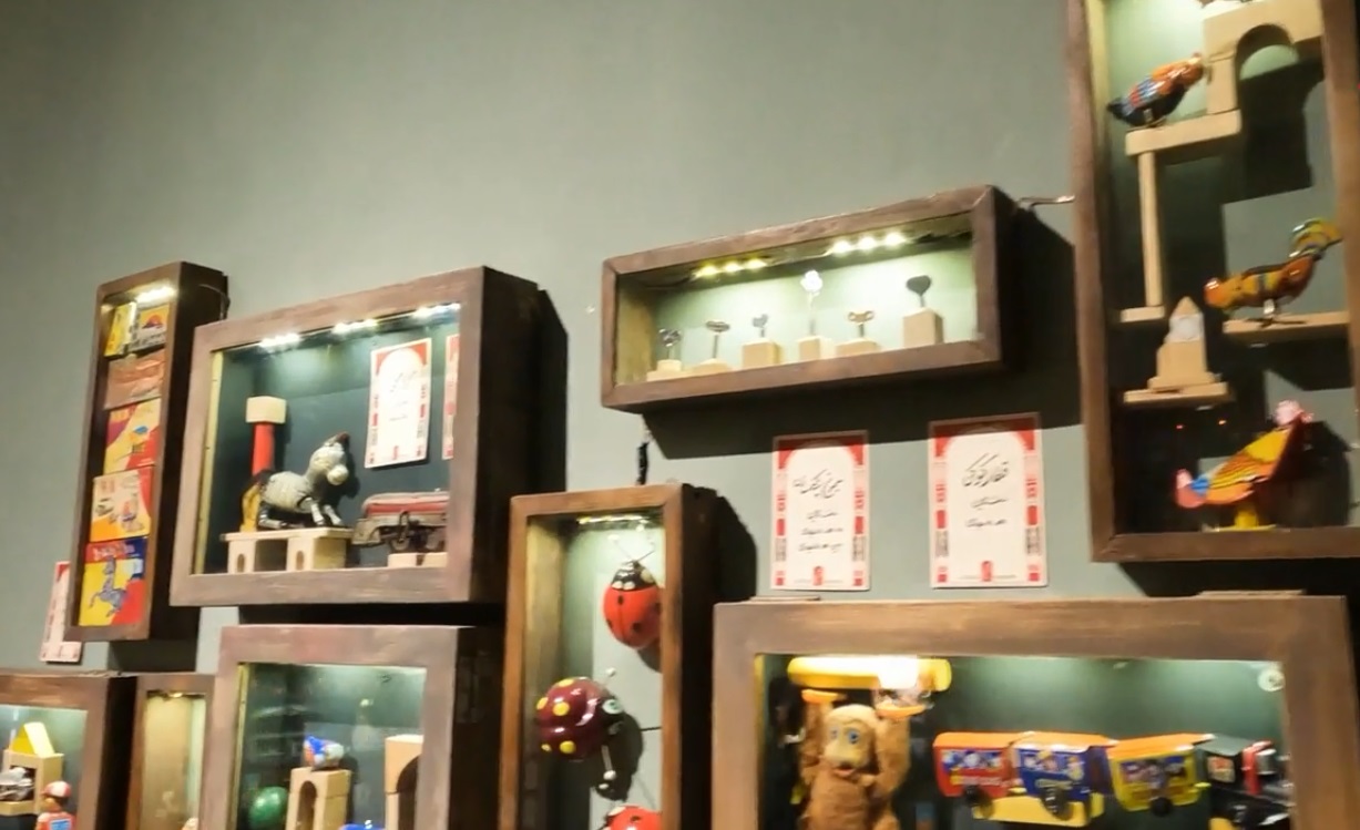 اسباب بازی های قدیمی در قفسه های روی دیوارهای موزه اسباب بازی تهران